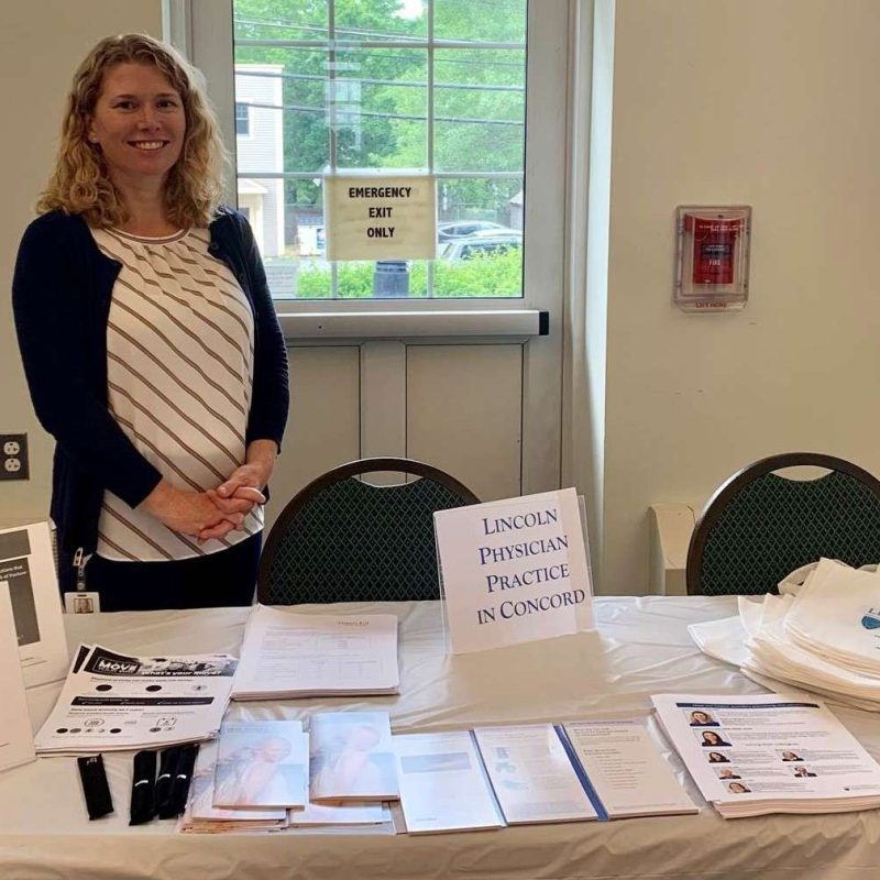 Dr. Beck standing at a table covered in information about Lincoln Physicians