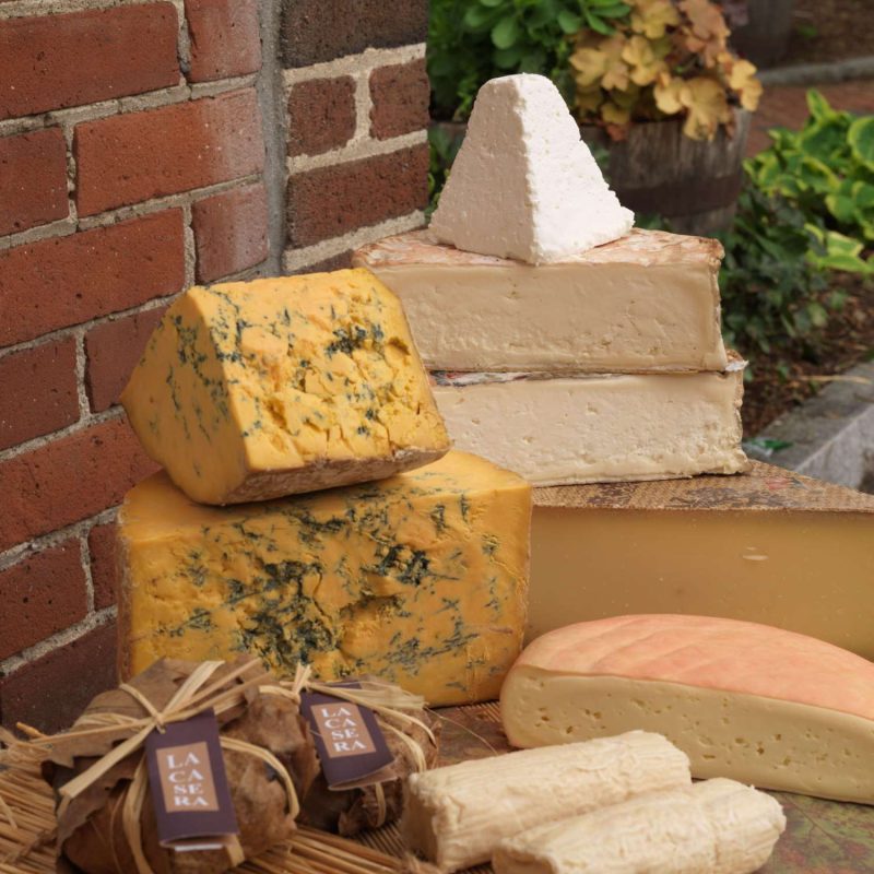 a stack of gourmet cheese on a straw mat